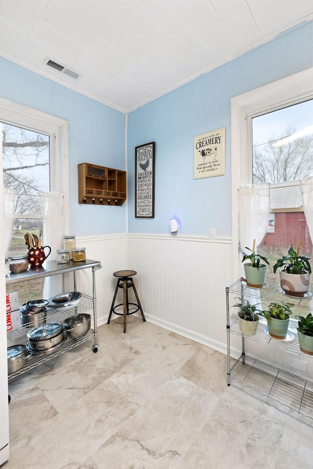 interior space featuring crown molding, a healthy amount of sunlight, and visible vents