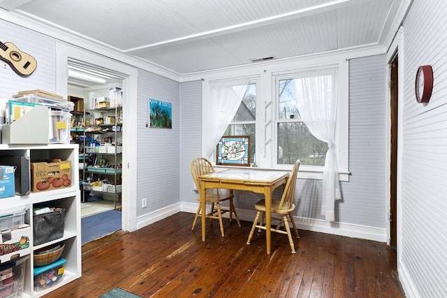 interior space featuring visible vents, wood-type flooring, baseboards, and ornamental molding