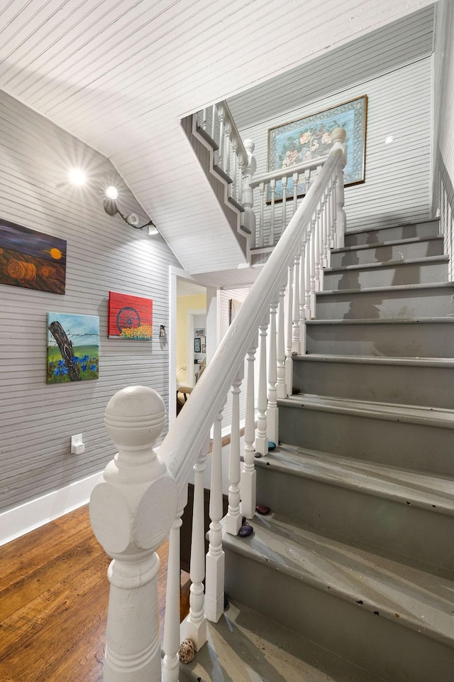 staircase with baseboards and wood finished floors