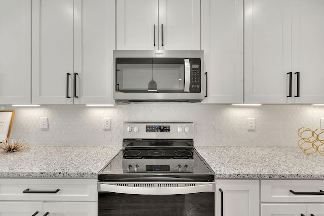 36 Wilson Ct, Ashland City, TN 37015 - kitchen with stainless steel microwave, backsplash, white cabinetry, and electric range oven