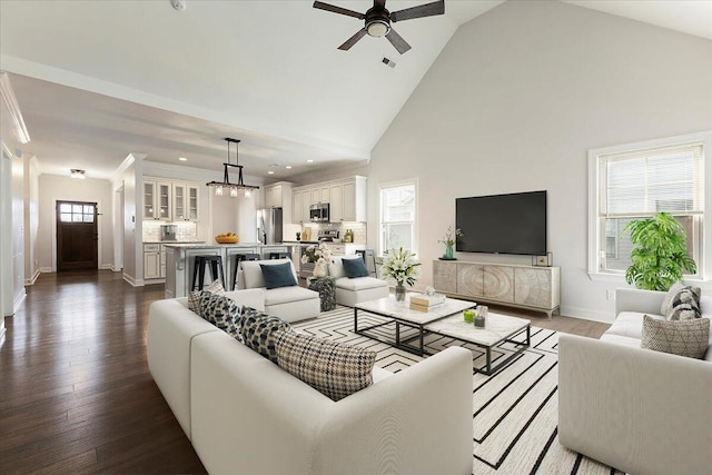 living room featuring dark wood-type flooring, high vaulted ceiling, ornamental molding, baseboards, and ceiling fan