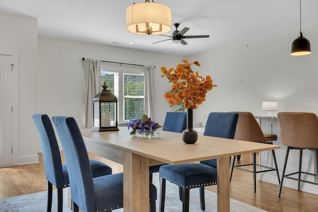 dining space with light wood-style floors and ceiling fan