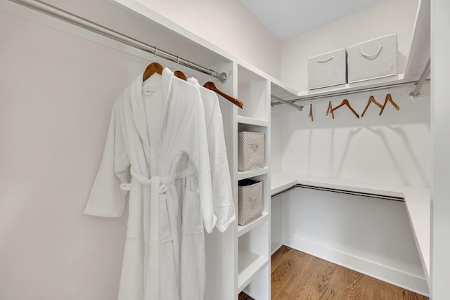 walk in closet with wood finished floors