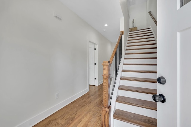 stairs with recessed lighting, baseboards, and wood finished floors