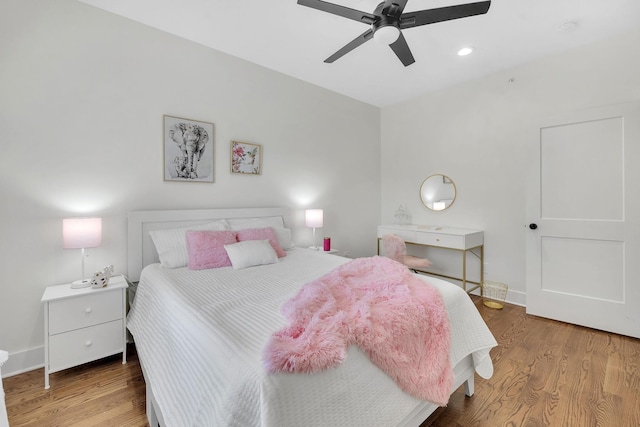 bedroom with a ceiling fan, baseboards, and wood finished floors