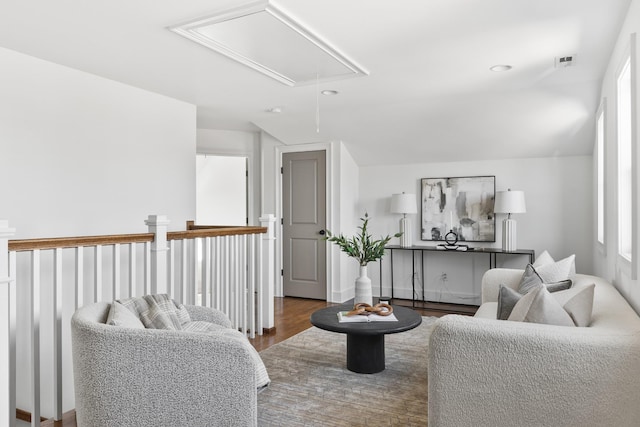 living area featuring attic access and wood finished floors