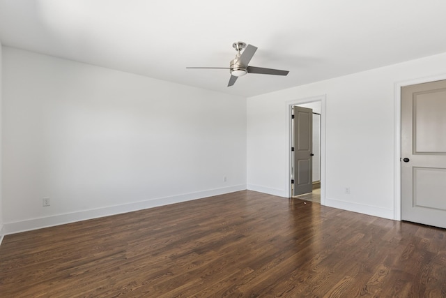 spare room featuring a ceiling fan, baseboards, and dark wood-style flooring