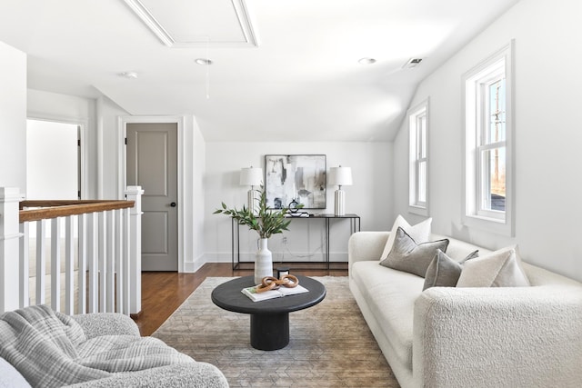 living room with attic access, dark wood-type flooring, baseboards, and vaulted ceiling