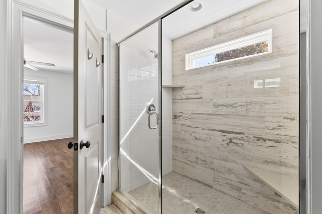 bathroom featuring a wealth of natural light, wood finished floors, and a stall shower