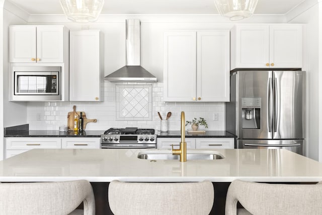 kitchen with a sink, stainless steel appliances, crown molding, wall chimney exhaust hood, and tasteful backsplash