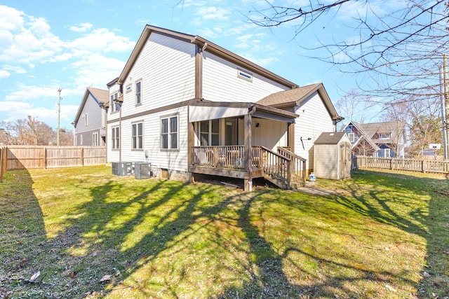 rear view of property featuring an outbuilding, a shed, a lawn, and a fenced backyard