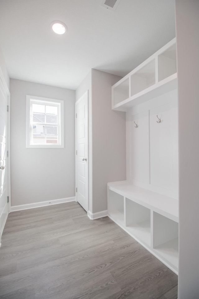 mudroom with visible vents, wood finished floors, and baseboards