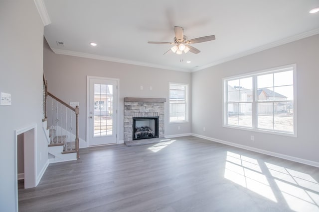 unfurnished living room with ornamental molding, a ceiling fan, wood finished floors, baseboards, and stairs