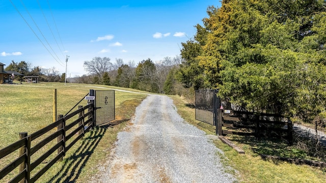 view of road with a rural view, a gated entry, driveway, and a gate