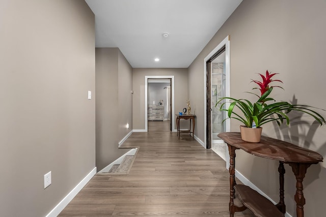 hallway with recessed lighting, baseboards, and wood finished floors