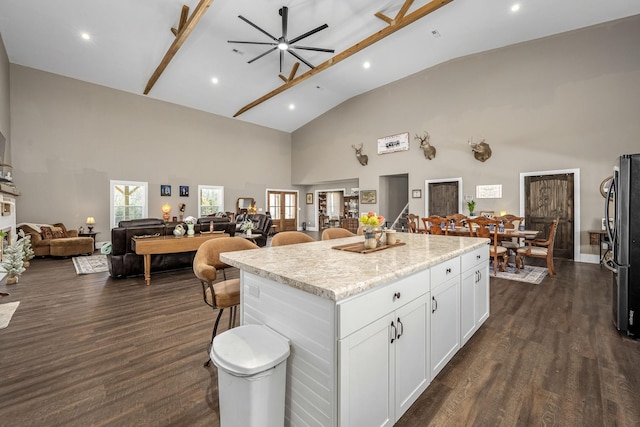 kitchen featuring freestanding refrigerator, dark wood-type flooring, white cabinetry, open floor plan, and a center island