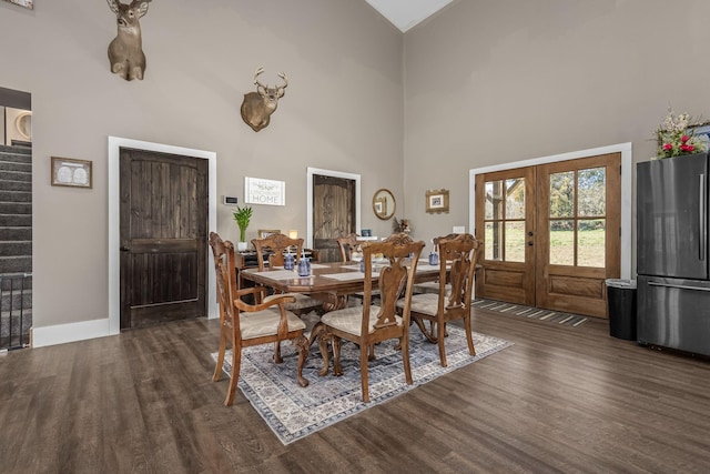 dining area with french doors, a high ceiling, dark wood-style floors, and stairs