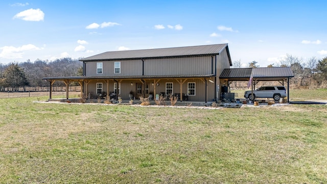 back of house with an attached carport, a porch, a lawn, and metal roof