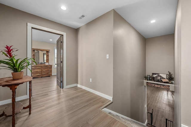 corridor featuring visible vents, recessed lighting, baseboards, and light wood finished floors