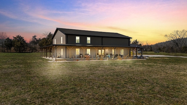 back of property with a lawn and metal roof