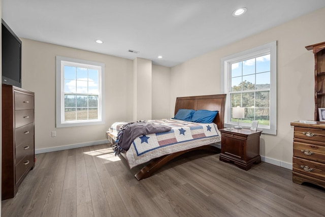 bedroom featuring recessed lighting, multiple windows, baseboards, and wood finished floors