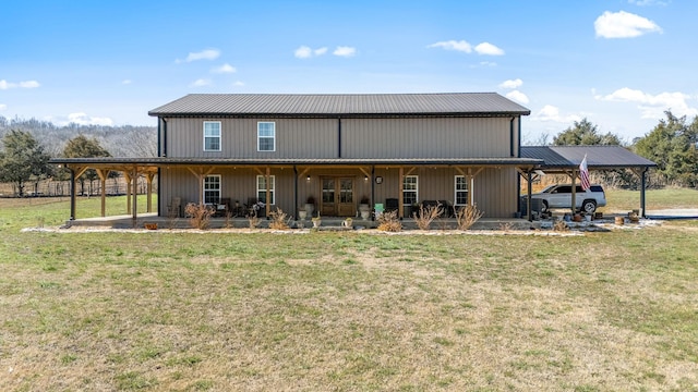 back of property featuring a carport, a yard, covered porch, and metal roof