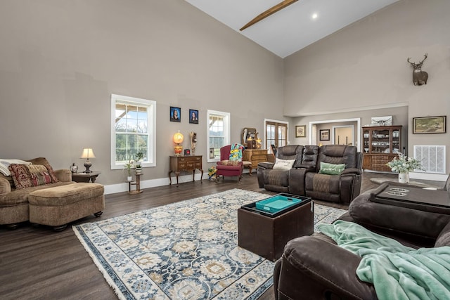 living area featuring dark wood-type flooring, baseboards, visible vents, and high vaulted ceiling