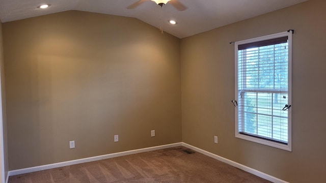 carpeted empty room with visible vents, ceiling fan, baseboards, and lofted ceiling