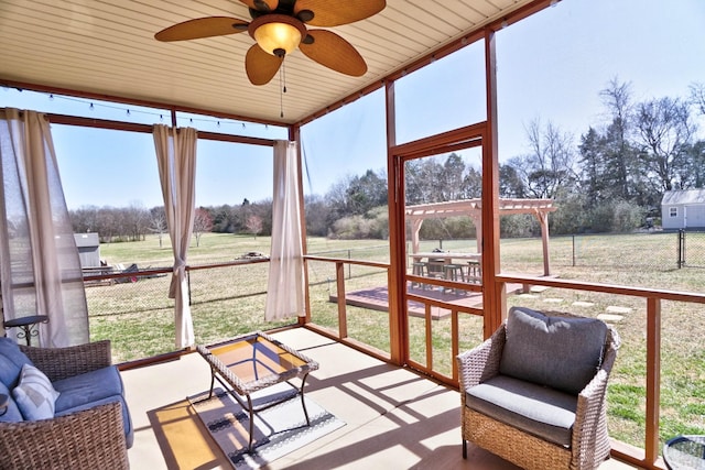 sunroom / solarium featuring a rural view and ceiling fan