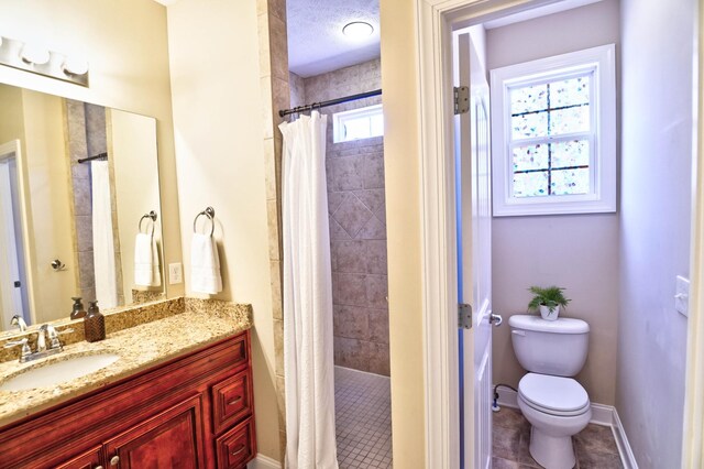 full bath with baseboards, toilet, tiled shower, tile patterned floors, and vanity