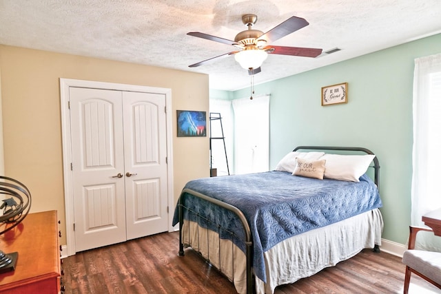 bedroom featuring wood finished floors, visible vents, a closet, and a textured ceiling