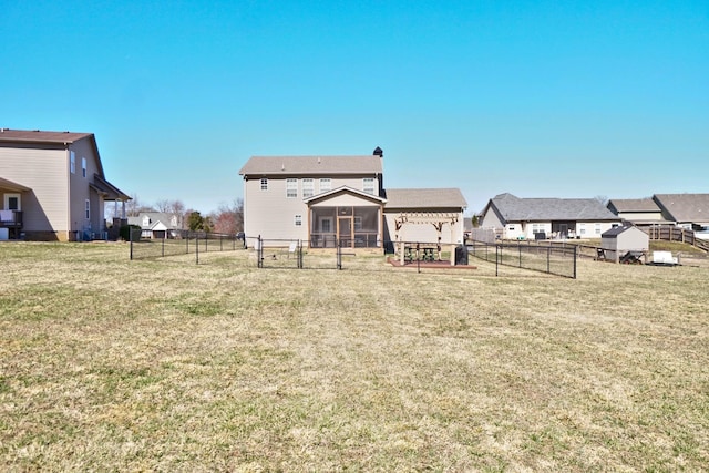 rear view of house featuring a residential view, a lawn, and a fenced backyard