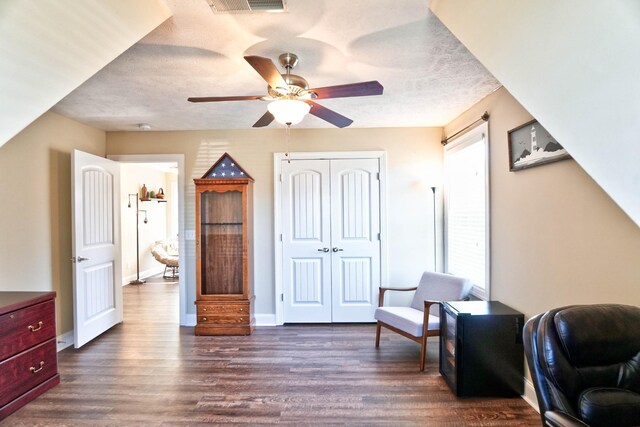 sitting room featuring visible vents, a ceiling fan, a textured ceiling, dark wood finished floors, and baseboards