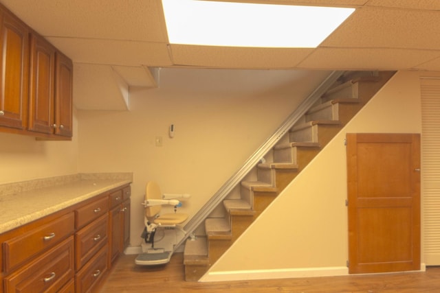 interior space with stairway, light wood-style floors, and a drop ceiling