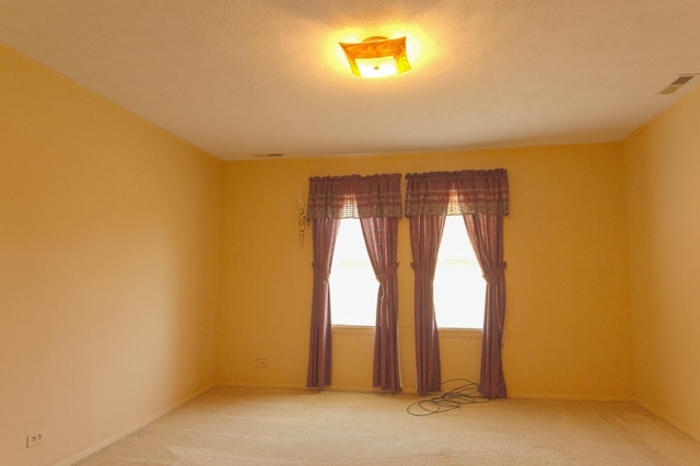 empty room with visible vents and carpet