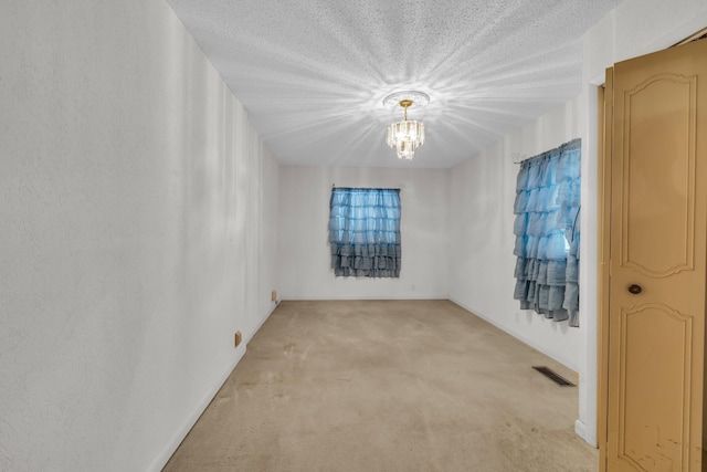 253 Main St, Ducktown, TN 37326 - spare room featuring light carpet, a chandelier, a textured ceiling, and baseboards