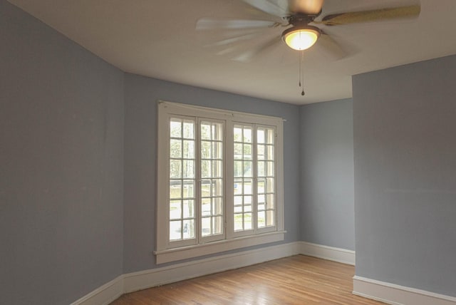 spare room featuring ceiling fan, baseboards, and wood finished floors