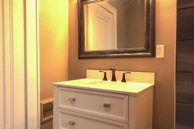 bathroom with vanity and a textured wall