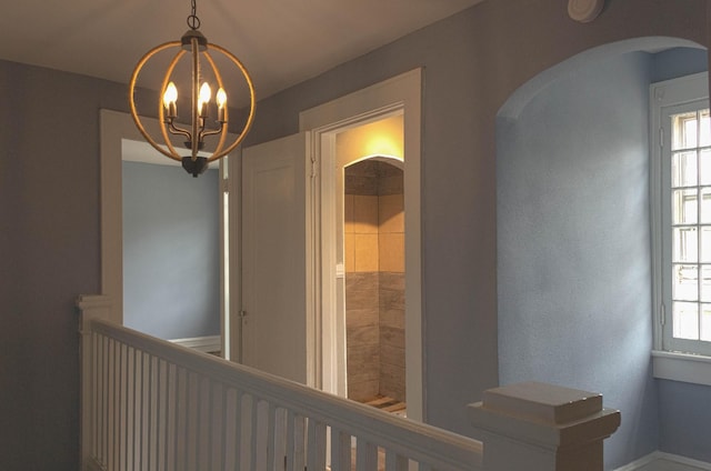 corridor featuring arched walkways and a chandelier