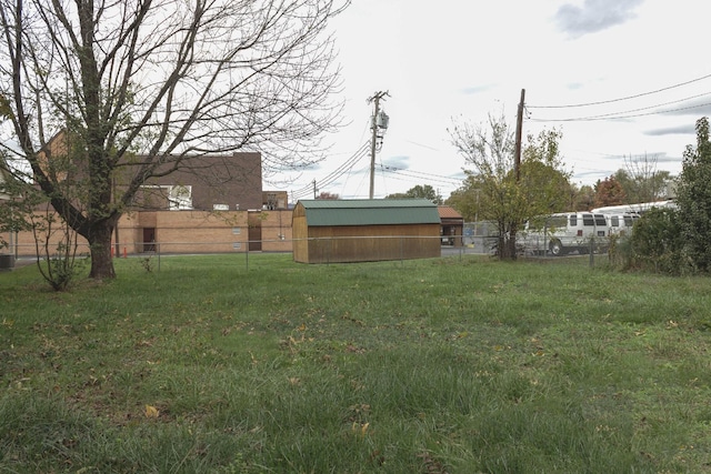 view of yard featuring a storage shed, an outbuilding, and a fenced backyard