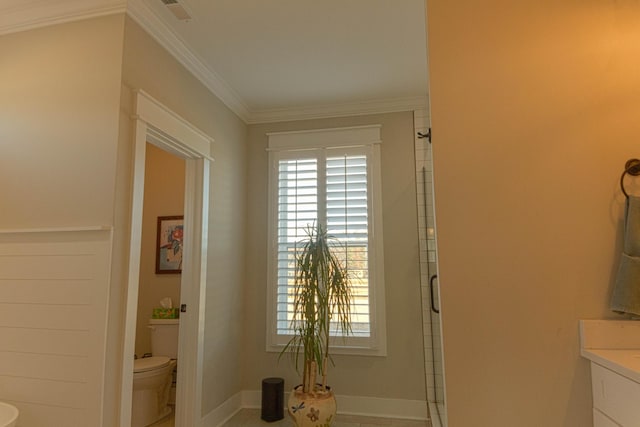 interior space with vanity, baseboards, visible vents, ornamental molding, and toilet