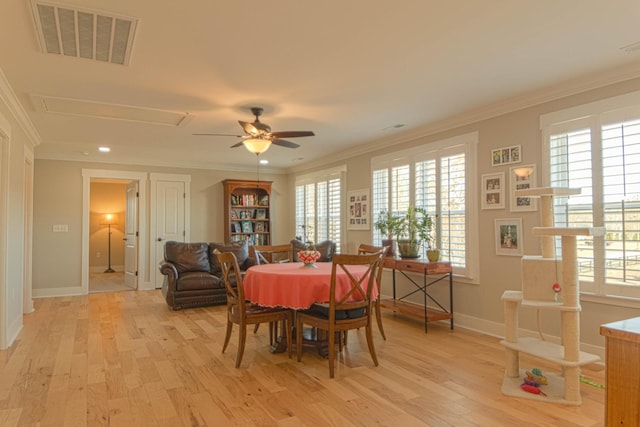 dining space with visible vents, a healthy amount of sunlight, light wood-type flooring, and crown molding