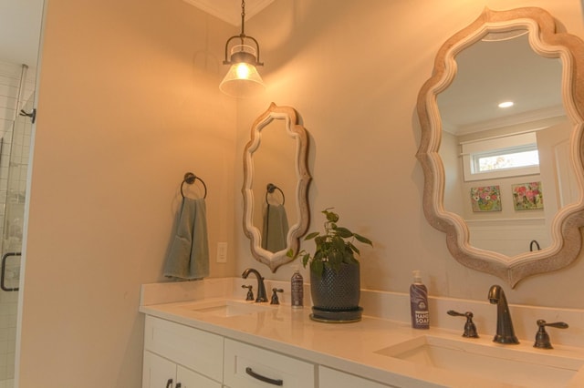 bathroom featuring double vanity, crown molding, and a sink