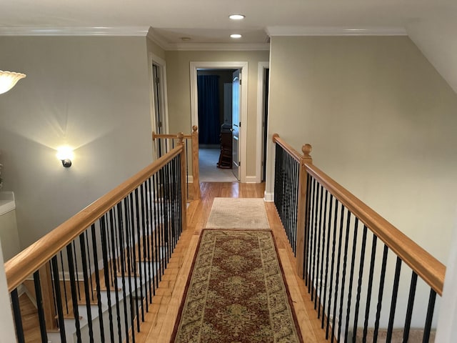 hallway featuring recessed lighting, an upstairs landing, light wood-style floors, and crown molding