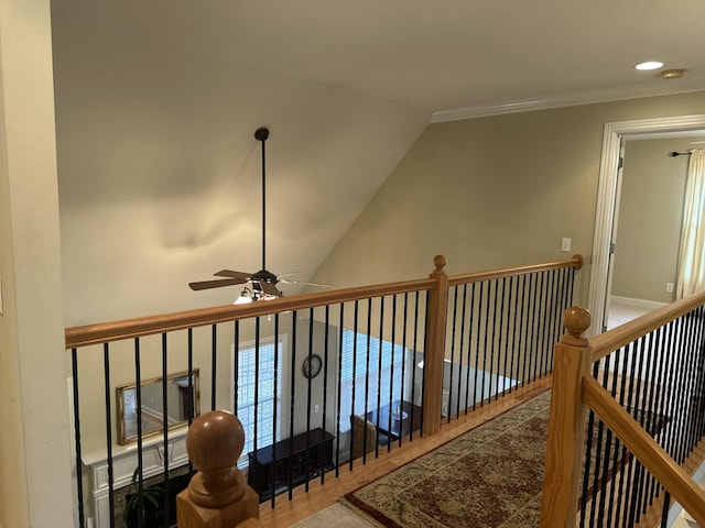 hallway featuring lofted ceiling, an upstairs landing, and ornamental molding