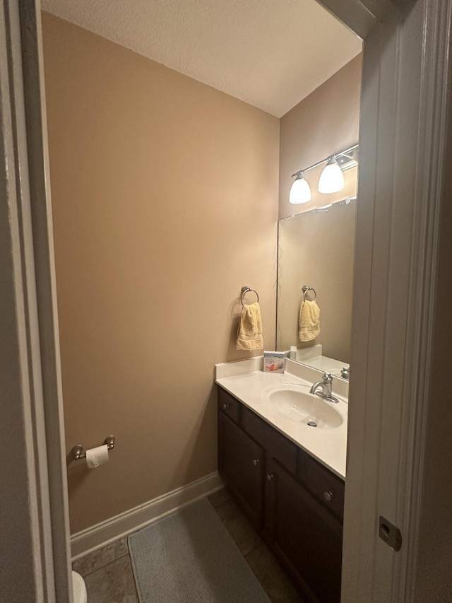 bathroom featuring tile patterned floors, vanity, and baseboards