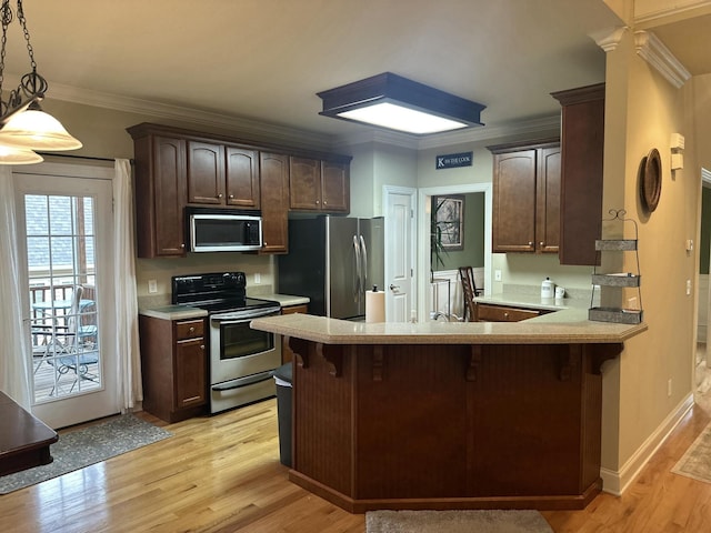 kitchen featuring stainless steel appliances, dark brown cabinetry, a peninsula, crown molding, and light countertops