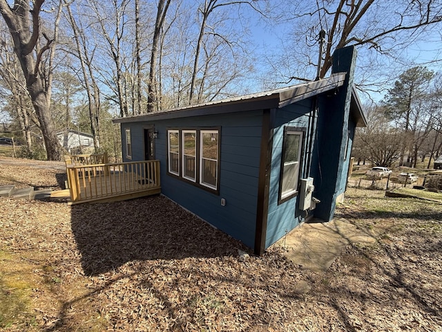 view of property exterior featuring a deck and metal roof