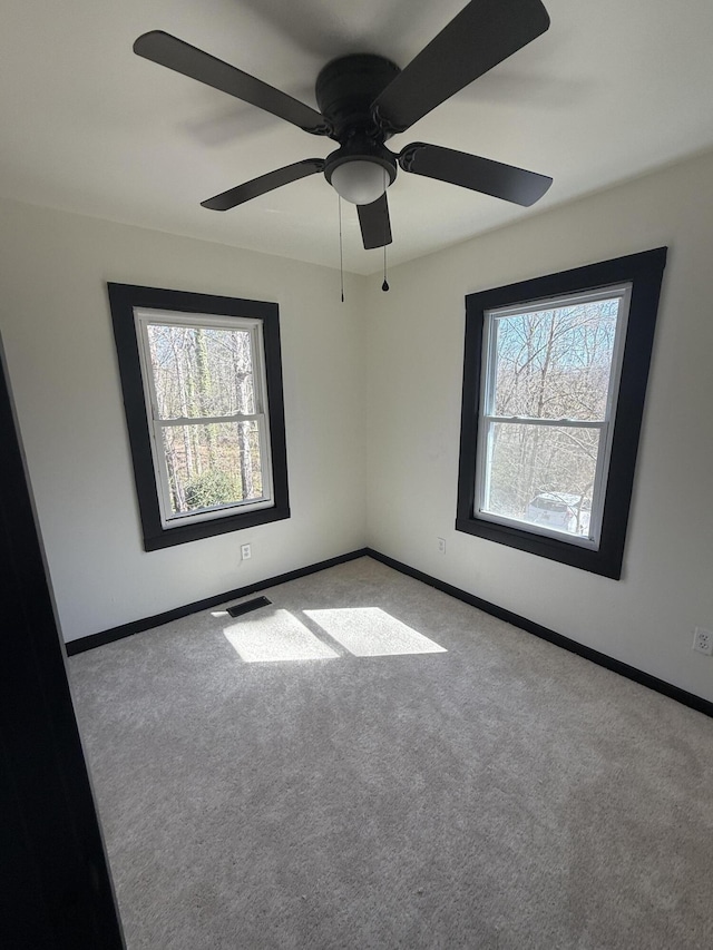 spare room with visible vents, carpet floors, and baseboards