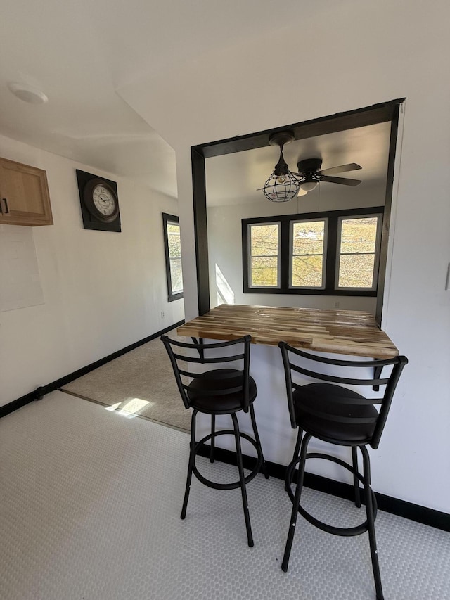 dining area featuring baseboards, carpet, and a ceiling fan